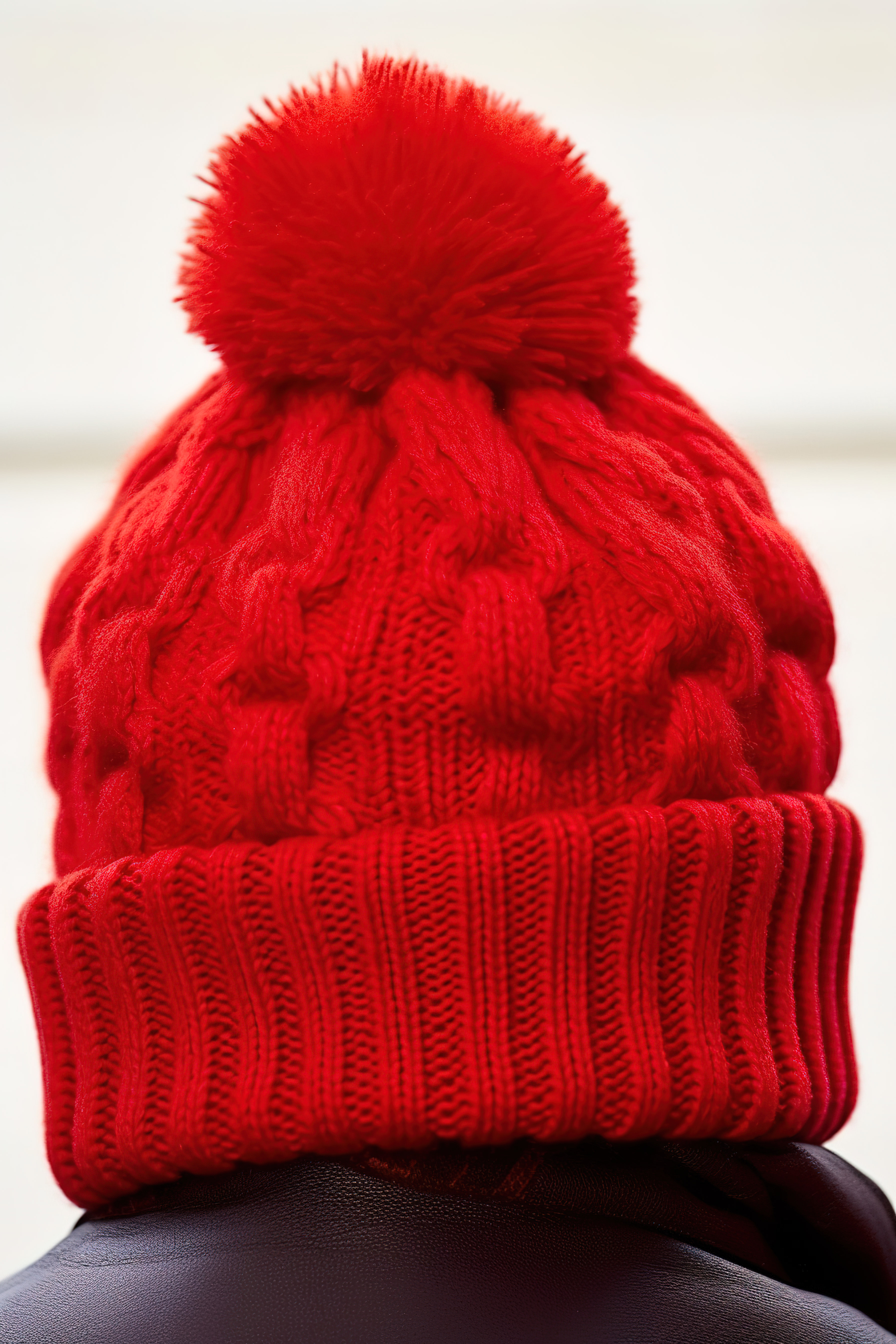 一顶红色的帽子，上面有一个 pom pom图片