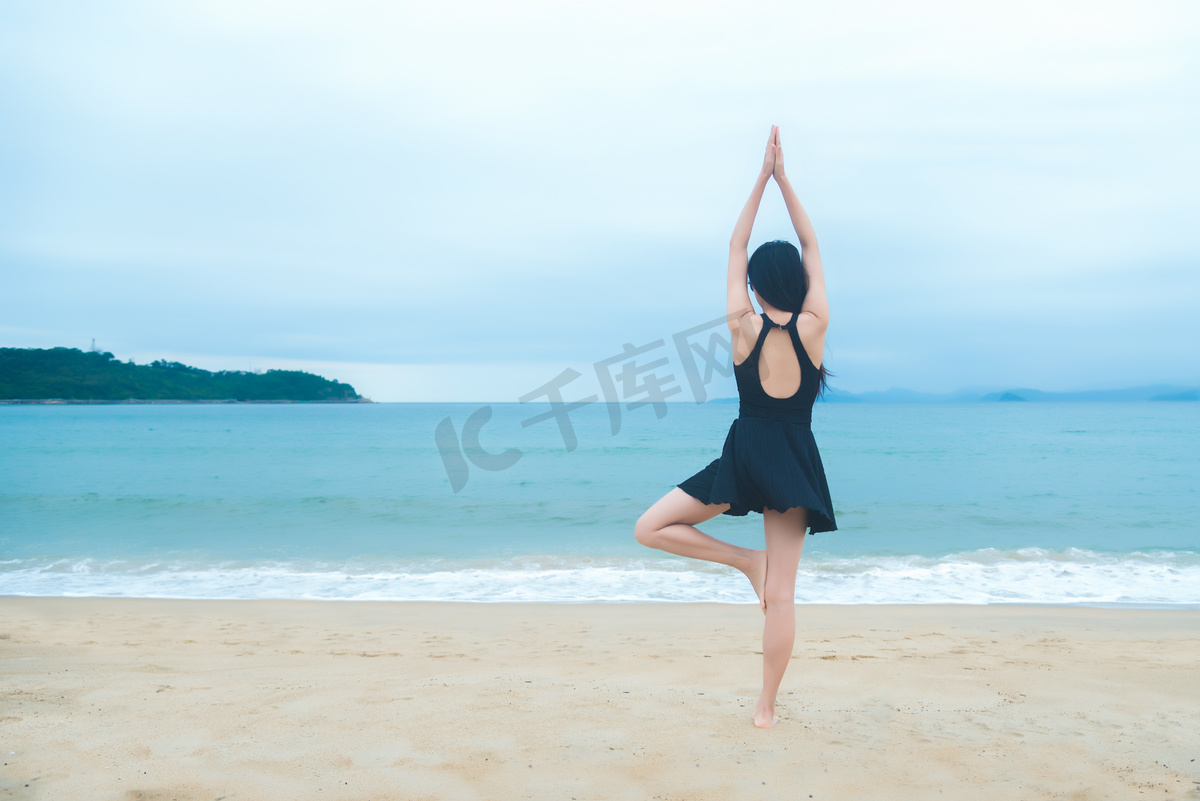 沙滩上进行瑜伽少女摄影图图片