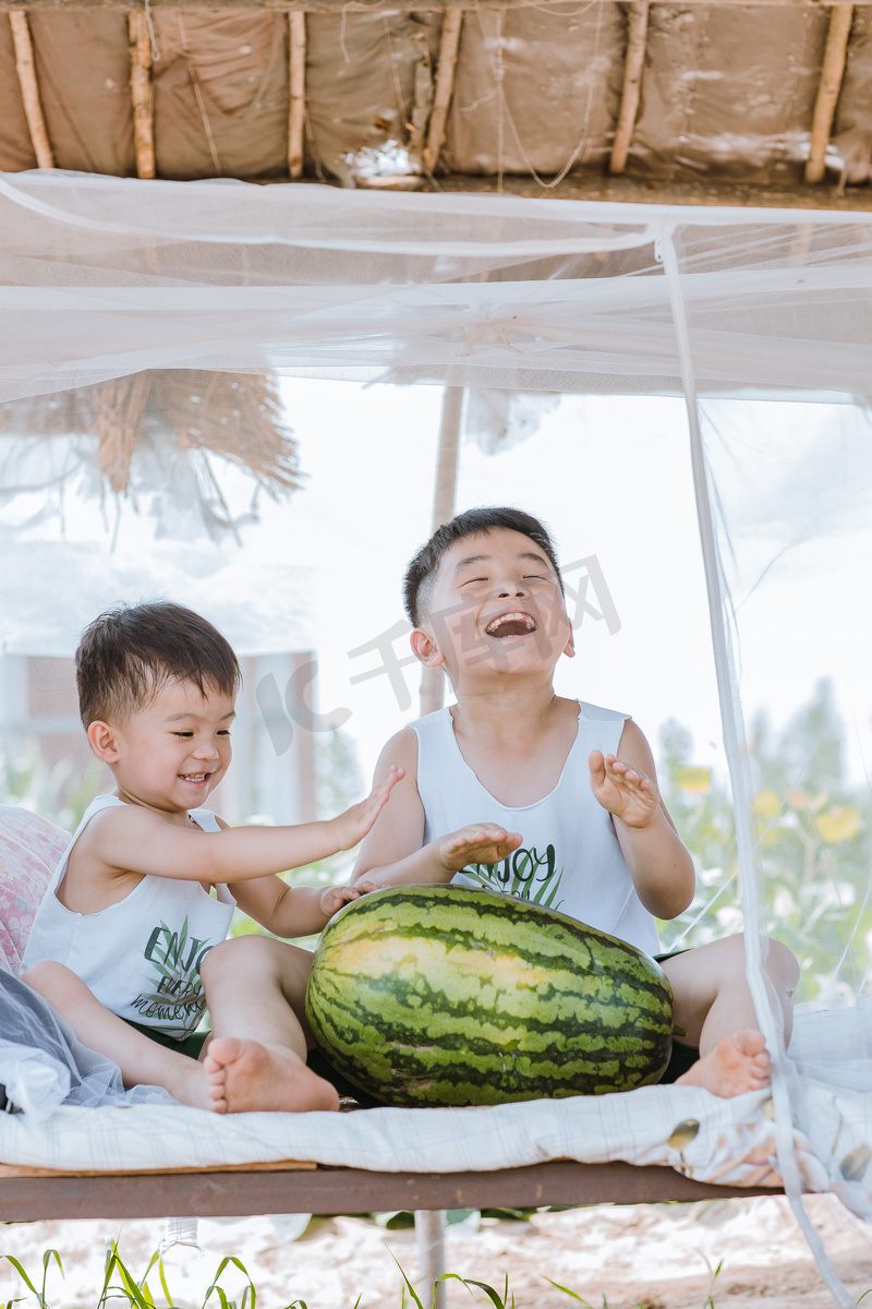 夏天瓜棚里的两个小孩子玩耍图片
