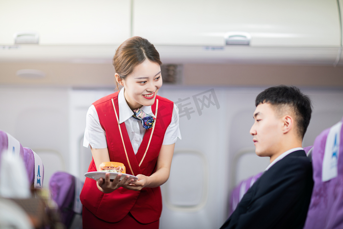 客舱服务白天空姐和男乘客客舱内端餐食摄影图配图图片