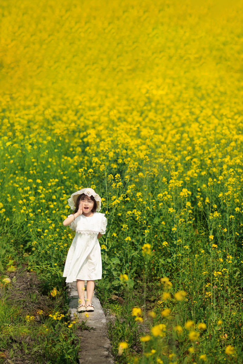文艺清晰的小女孩在油菜花里开心的玩耍摄影图配图图片
