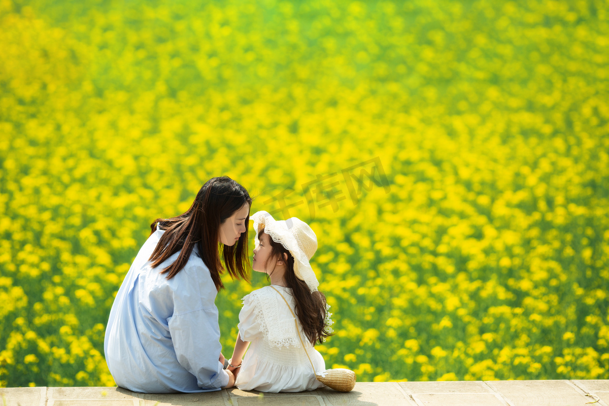 妈妈陪孩子在油菜花地开心的玩耍唯美摄影图配图图片