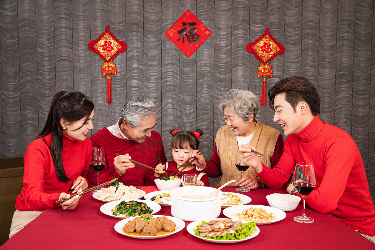 幸福的一家五口吃年夜饭给孩子夹菜摄影图配图图片