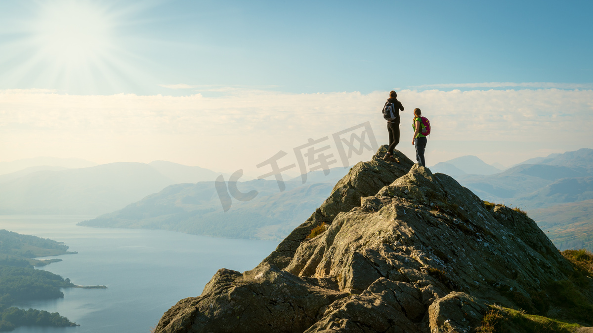 在山顶上享受谷的两位女性徒步查看，Ben A'an，卡特琳湖，高地，苏格兰，英国图片