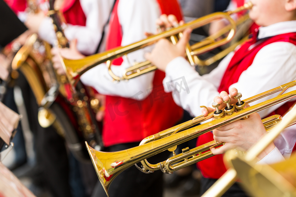 爵士乐队性能概念-乐团的管乐器在综艺节目中，选择性专注于手的音乐家演奏小号和萨克斯管、 特写男性在红色音乐会服饰.图片