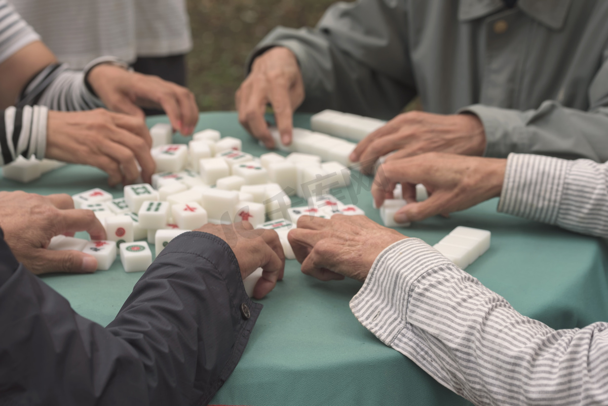 麻将牌游戏。在桌上打麻将。人们在公园里玩棋盘游戏图片