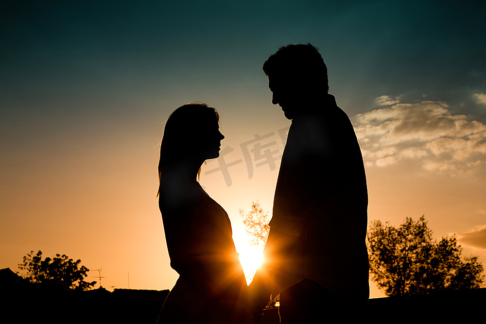 一对相爱的情侣在夏天的夕阳下相互抚摸着背光图片