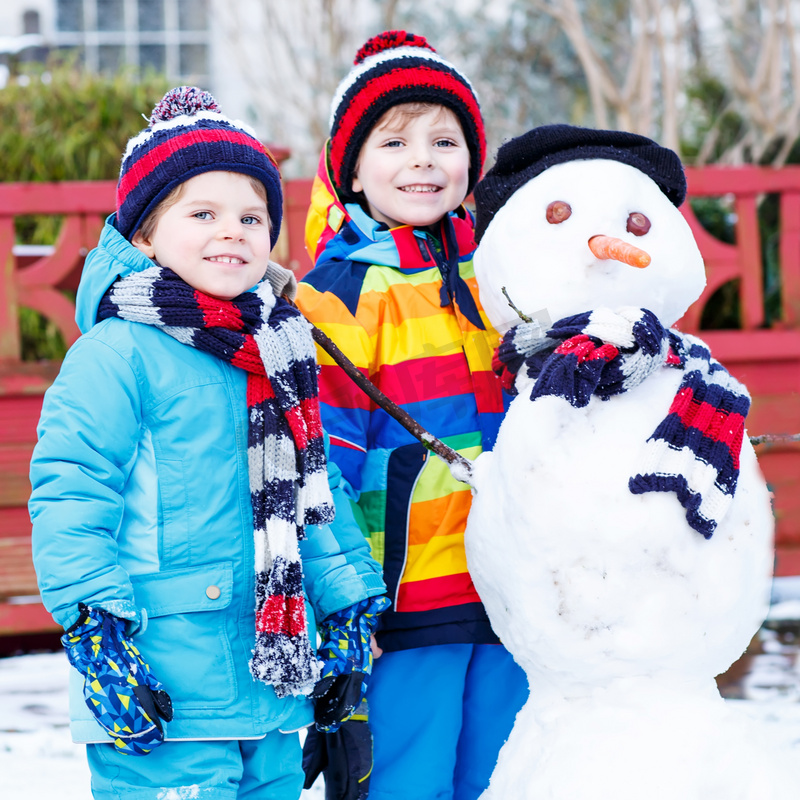 两个小姐妹男孩堆雪人、 打和有福图片