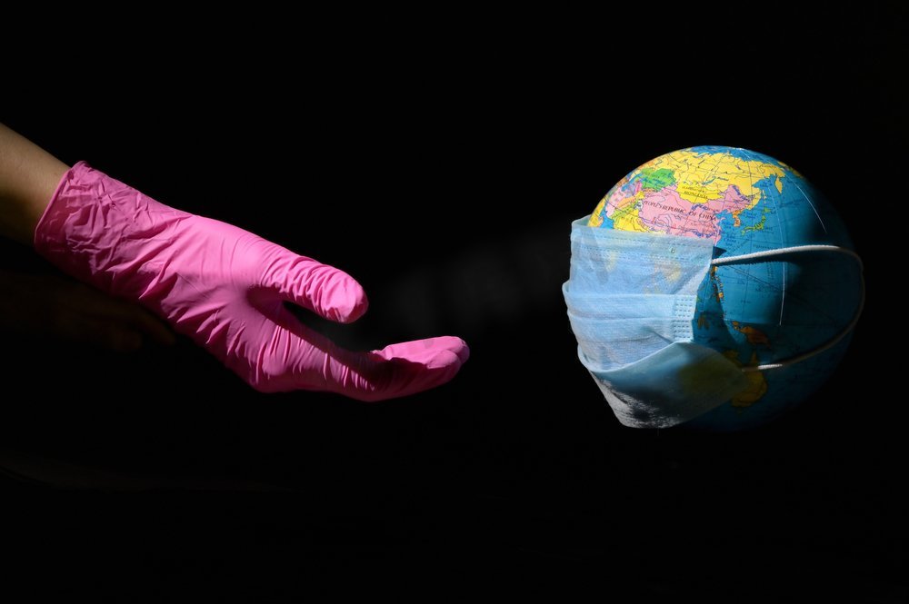 女人的手和地球与面具对抗病毒图片