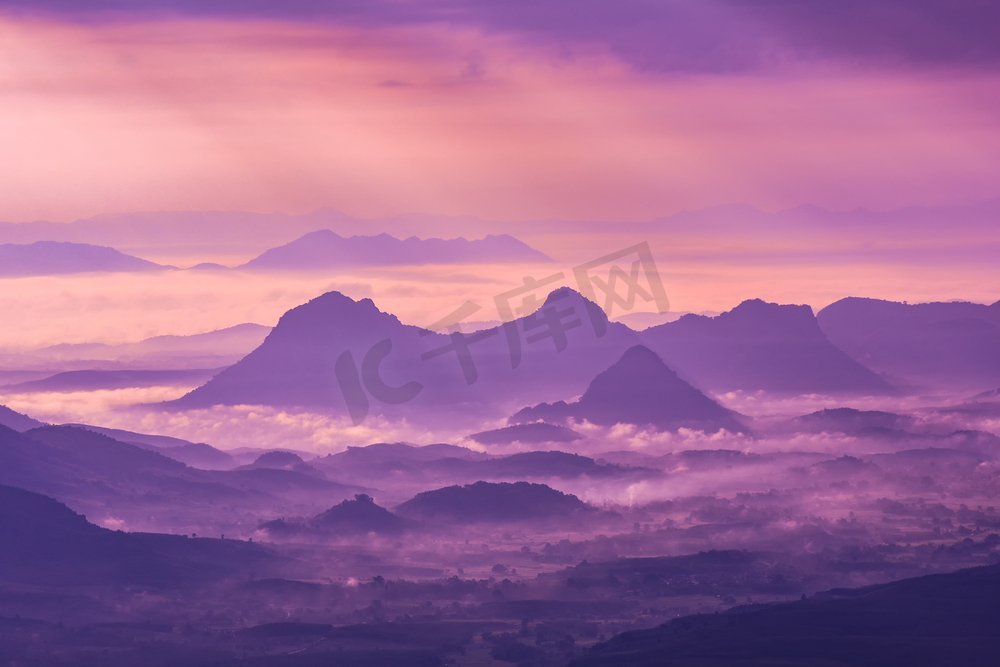 风景山有雾雾紫色天空和升起的太阳在上午在小山—剪影山脉背景图片