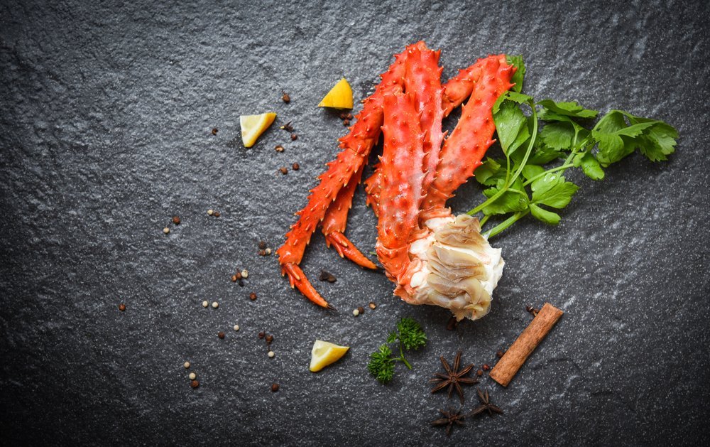 阿拉斯加国王蟹腿熟与柠檬欧芹香草和香料在黑暗背景/红蟹北海道海鲜图片