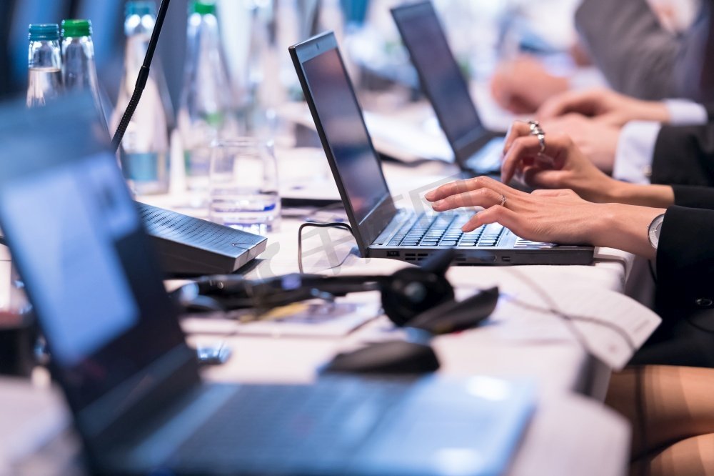 在大现代会议室的商业研讨会期间商业人手键入在膝上型计算机键盘的特写镜头图片