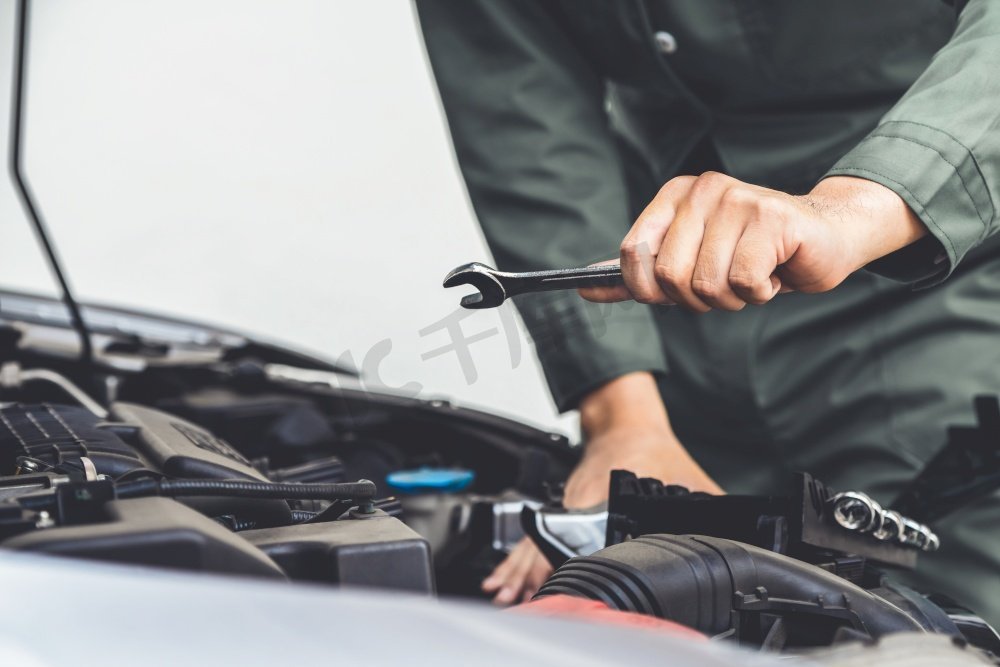 专业技工手提供汽车维修和保养服务在汽车修理厂。汽车服务的经营理念。图片