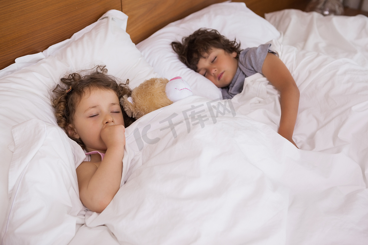 睡在床上的年轻女孩和男孩图片