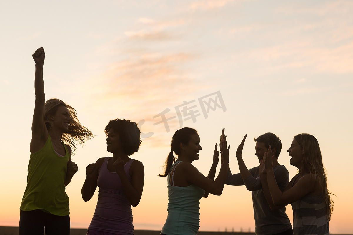 欢呼日落的快乐运动女性图片