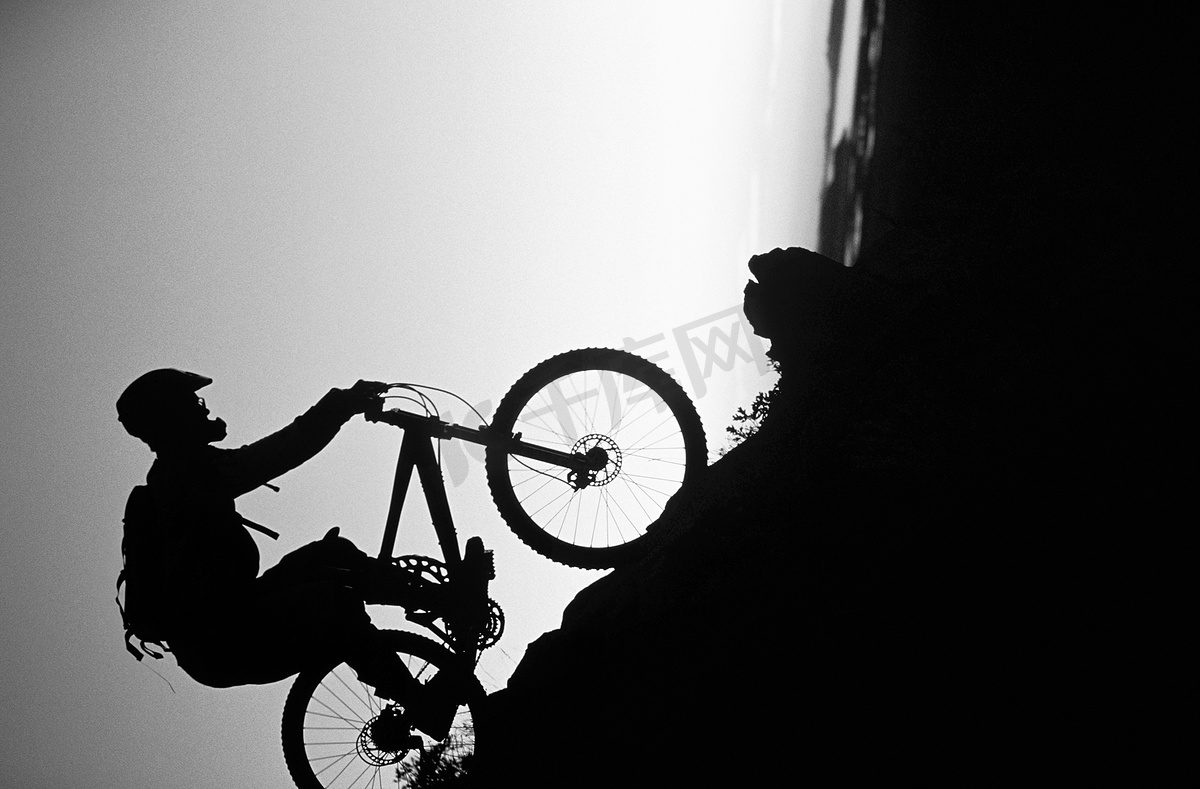 山地车手骑下斜坡的黑白照片图片