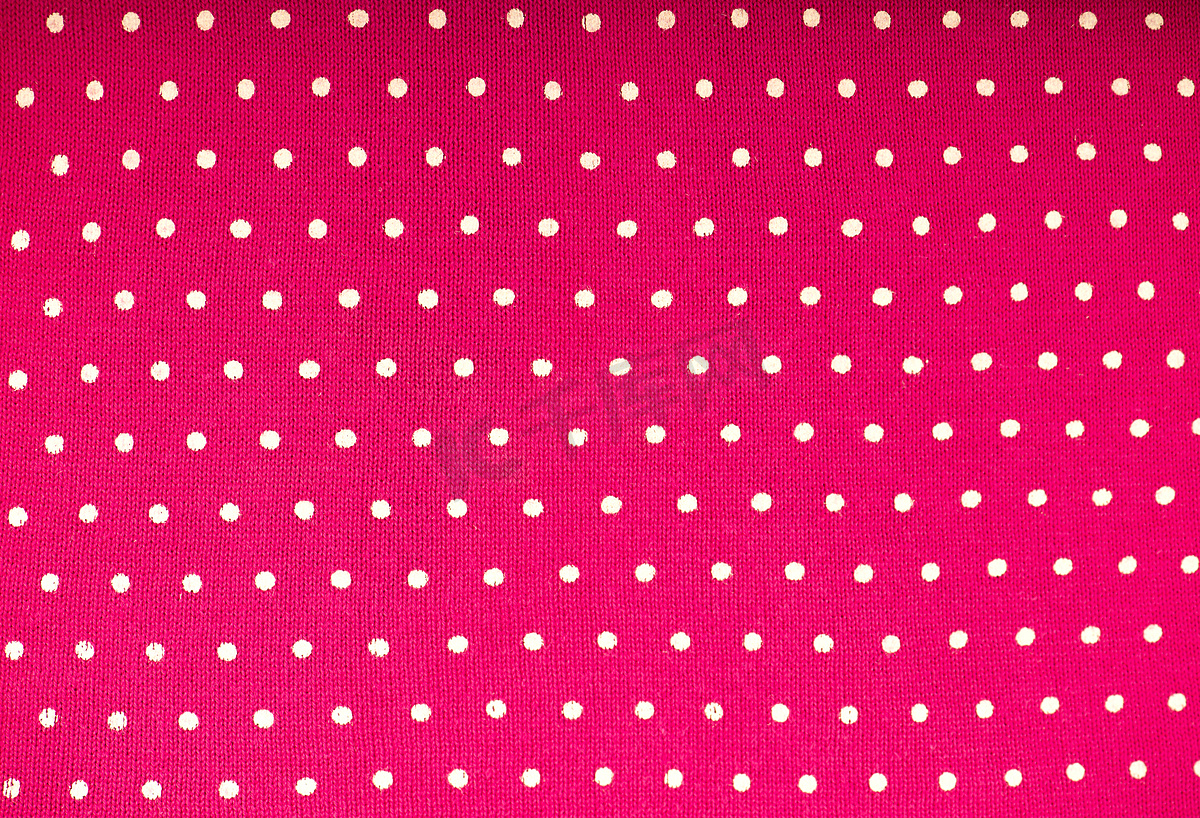 浅粉色背景上的波尔卡圆点的粉色圆点织物。图片