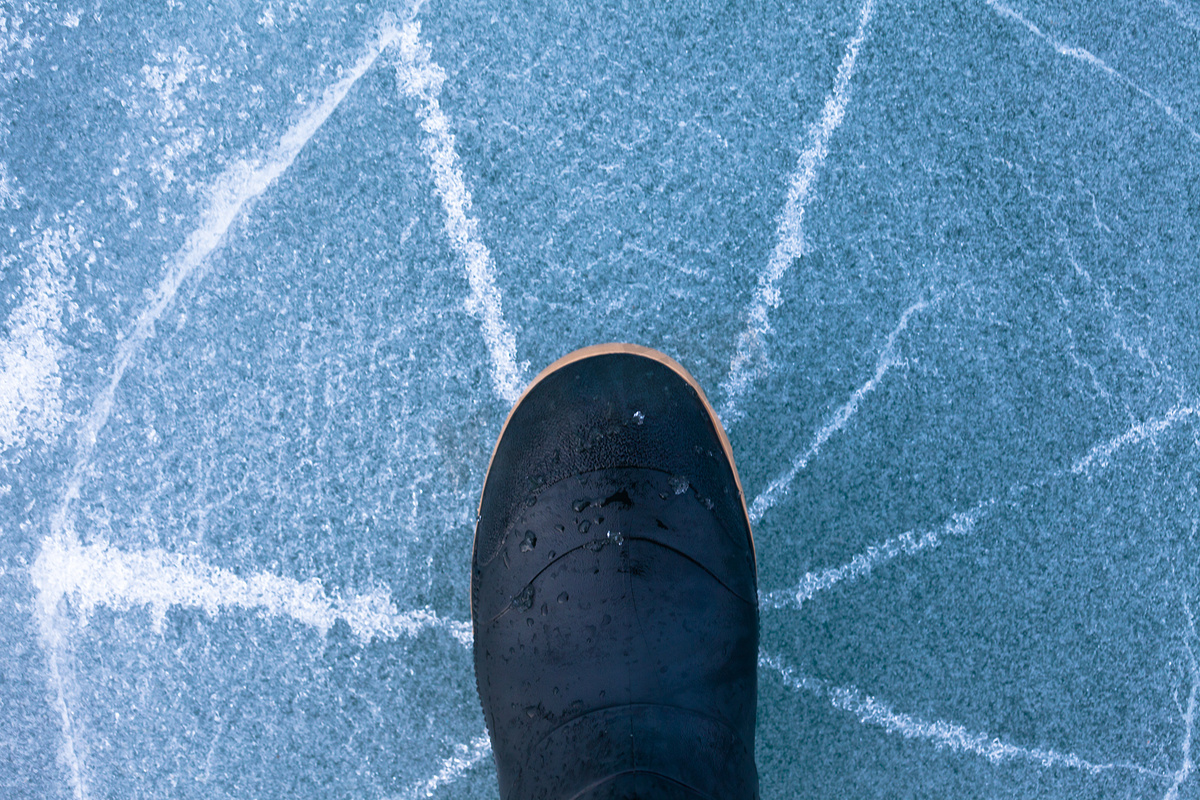 橡胶靴下的危险薄冰呈放射状破裂图片