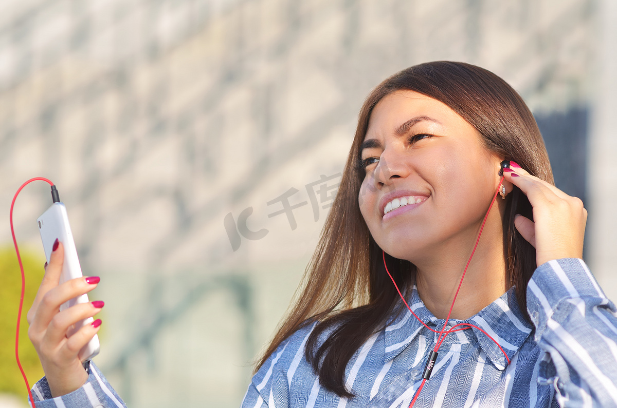 美丽的女孩在阳光明媚的春日听音乐享受生活图片