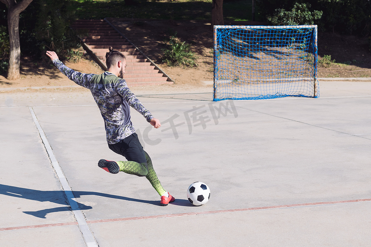 足球运动员将球踢入空门图片