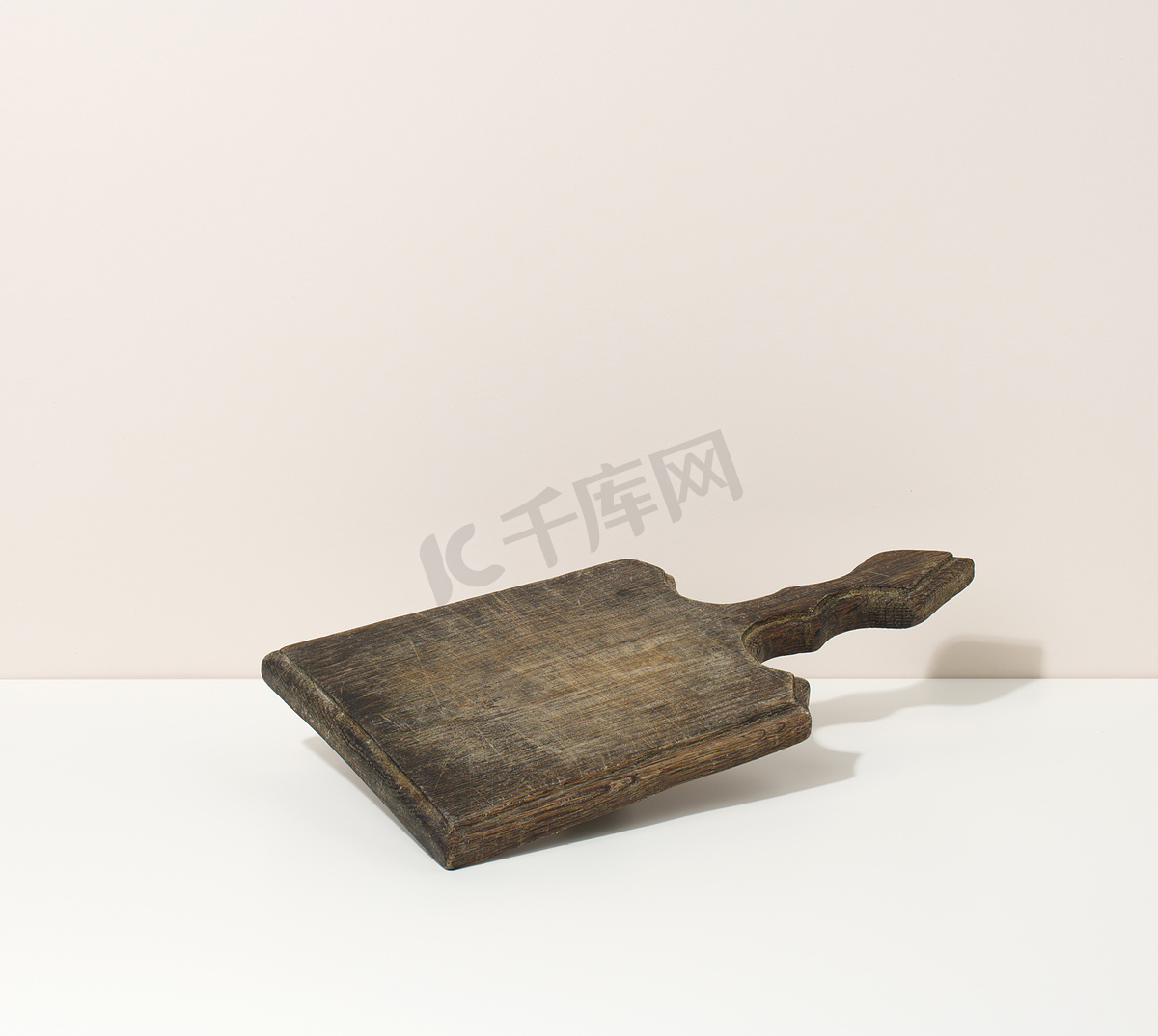 白色桌子上的矩形空棕色木制厨房板，餐具。图片