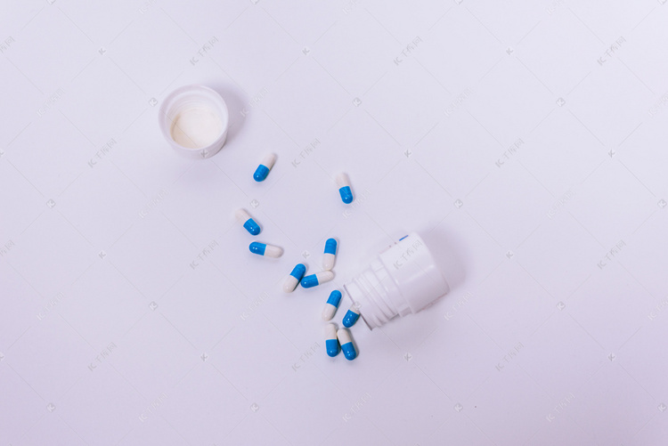 打开的药瓶与倒出的胶囊摄影图