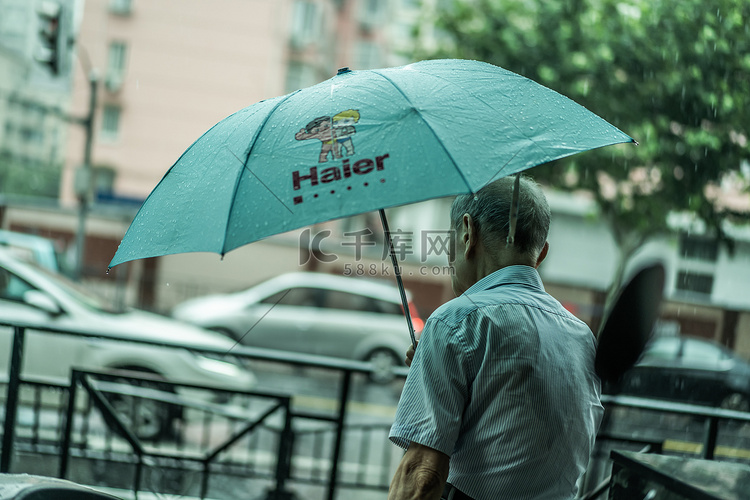 上海下雨天街道打伞的老人
