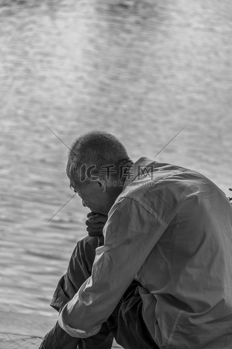 老人老者孤独坐在湖边