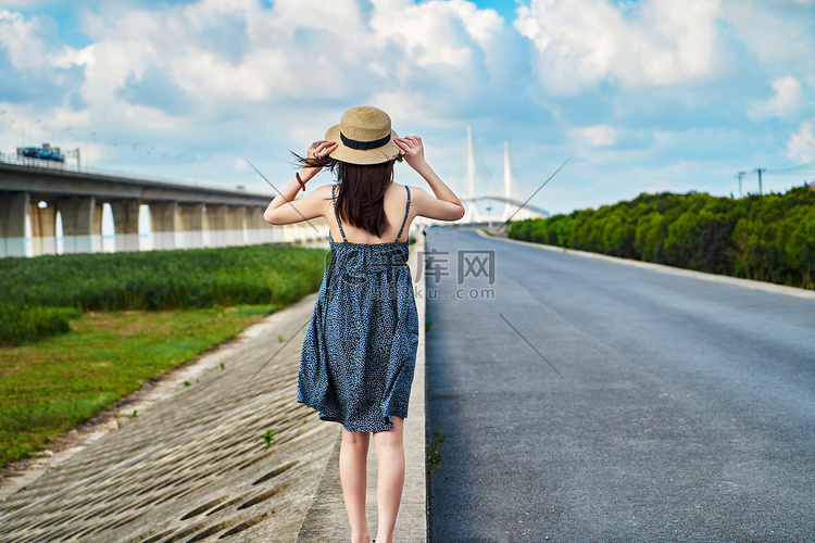 公路旁夏日晴空帽子女生蓝天白云