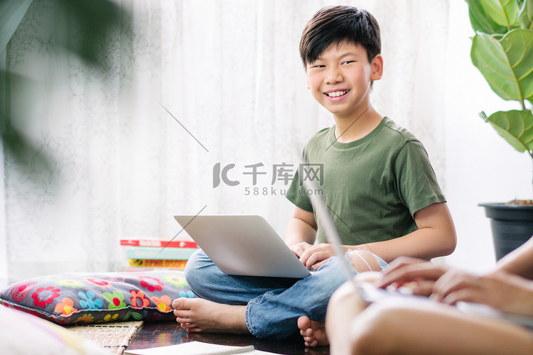 聪明的亚洲少年使用电脑笔记本电
