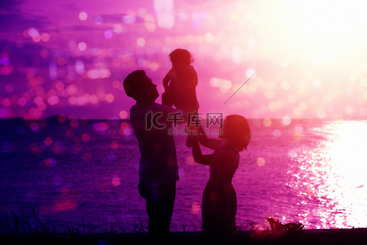家庭在户外海边日落的剪影