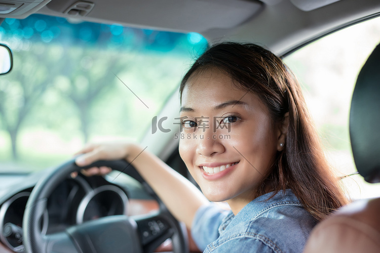 美丽的亚洲女人笑着欣赏着开车上
