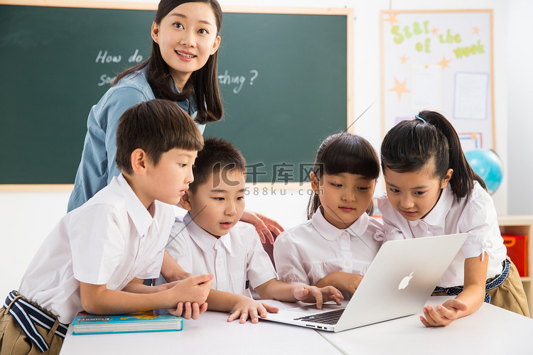 教师和小学生在教室里使用电脑