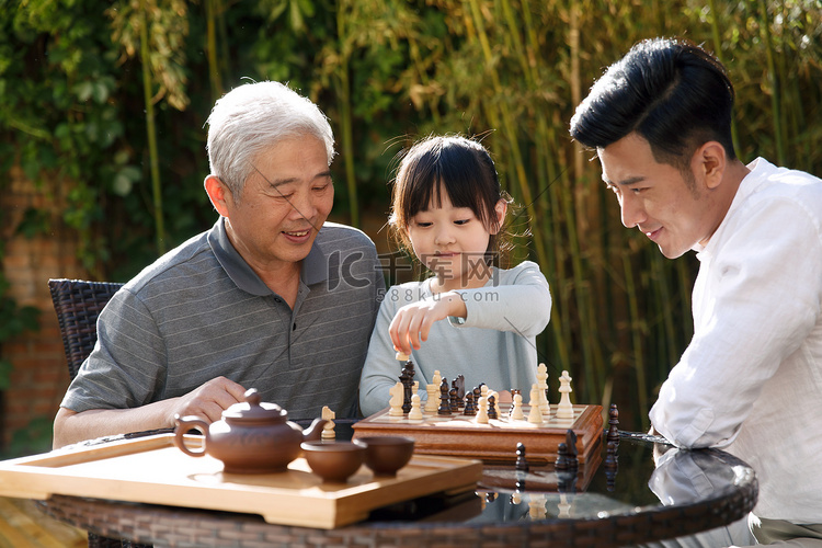 祖孙三代在庭院里下棋