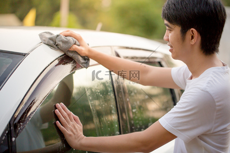 快乐的亚洲人，洗他的车在家里