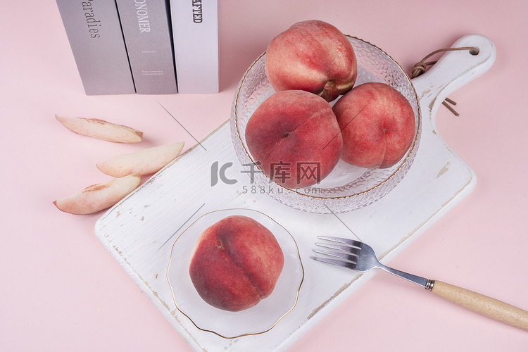 粉色系砧板桃子水果与叉子摄影图