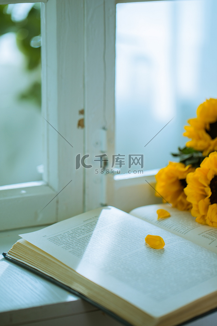 放在窗台上的向日葵和书