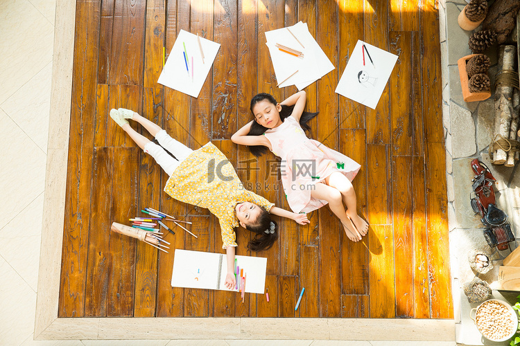 姐妹俩躺在地板上玩耍