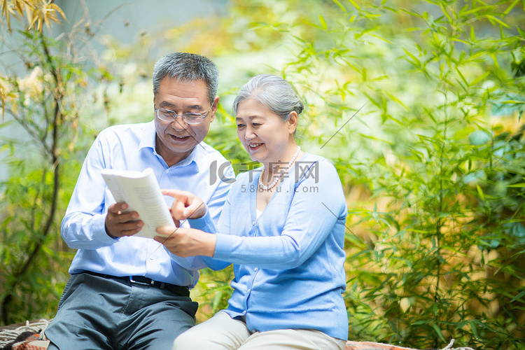 老年生活白天老夫妻户外看书摄影