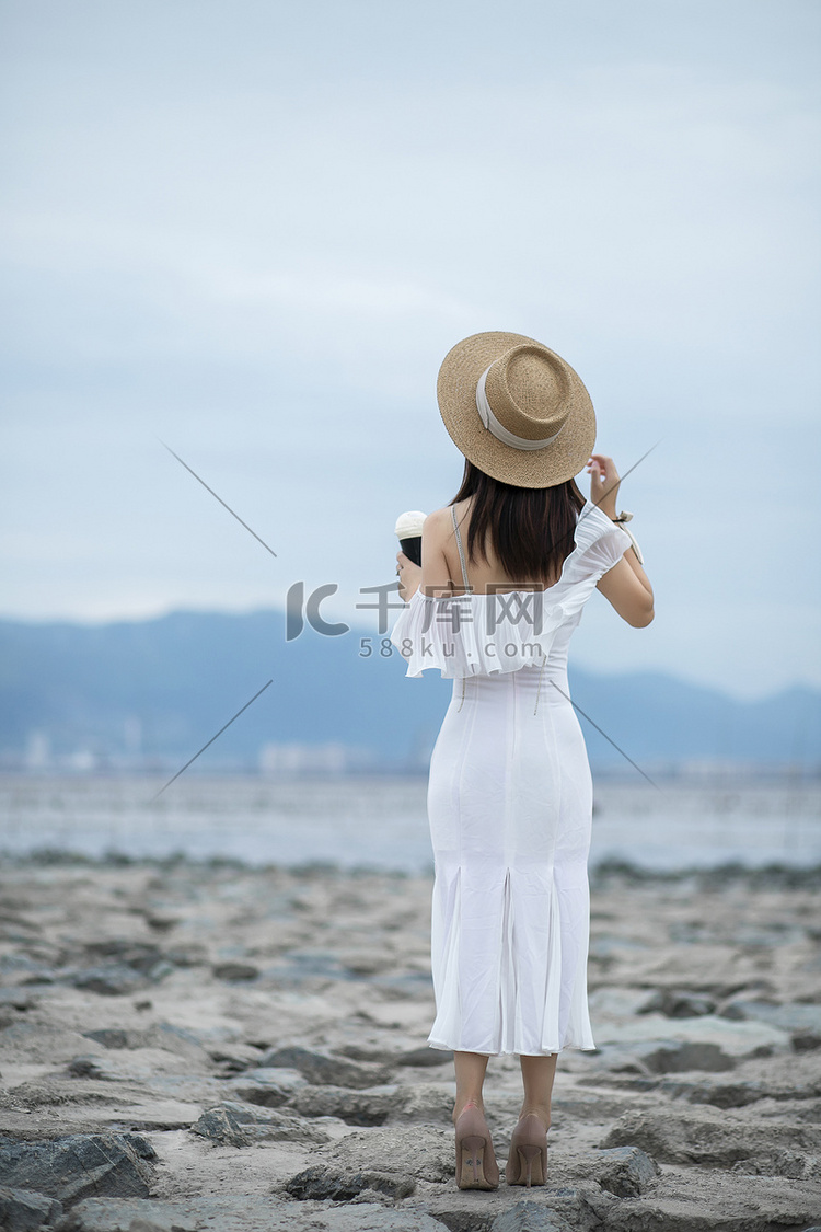 滩涂上的女子背影摄影图配图
