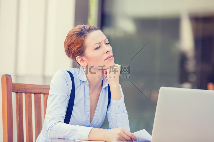 不满担心的商业女人坐在笔记本电