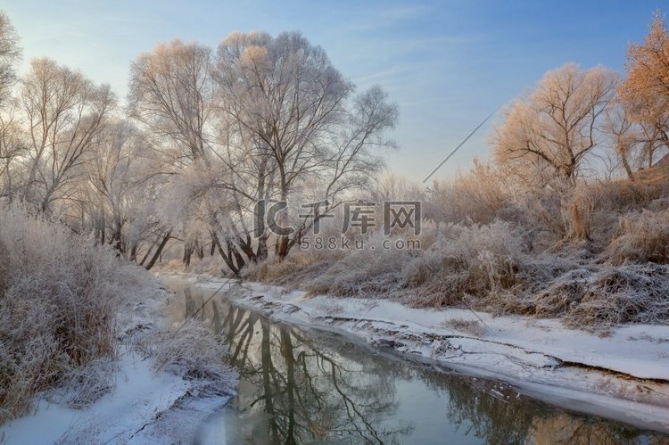 树木和河流结了霜的雪景