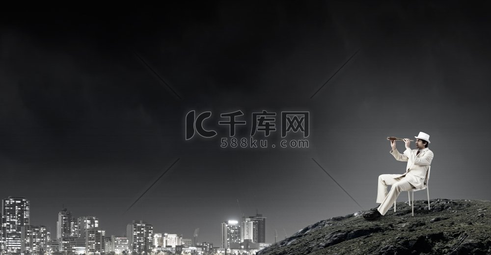 寻找未来的视角。一位穿着白色西装戴着帽子的商人坐在椅子上，看着望远镜