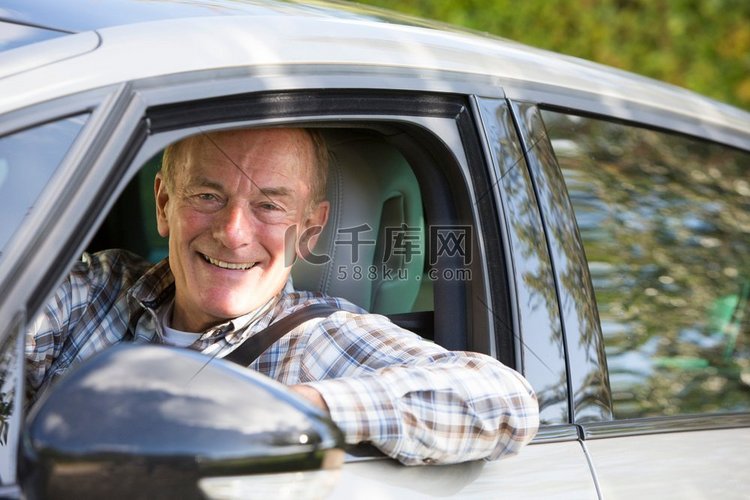 肖像微笑的高级男子驾驶汽车
