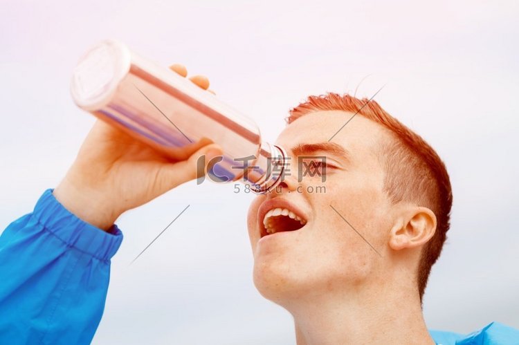 一名男子从运动瓶里喝水。运动中