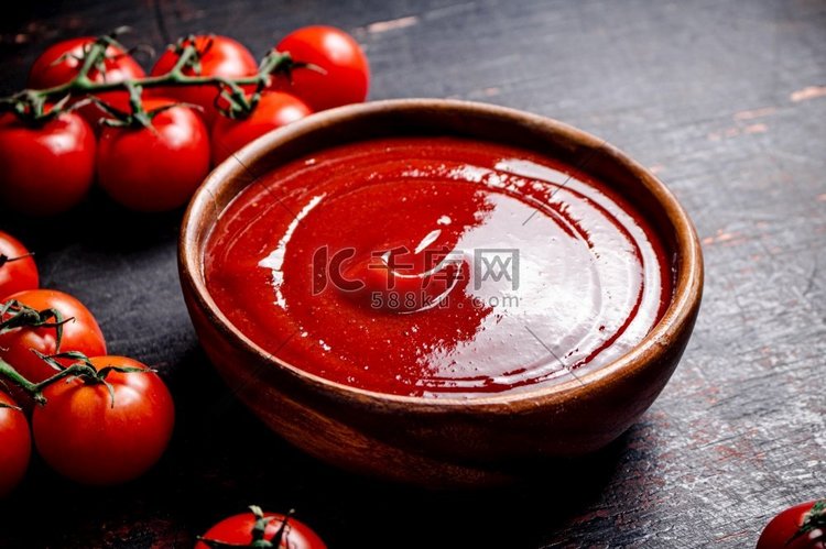 木盘子里的番茄酱。在黑暗的背景