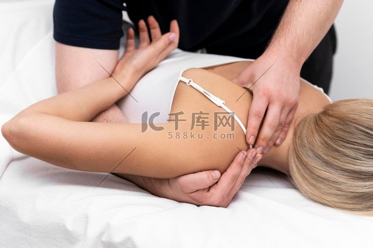 理疗师进行背部按摩的女性患者