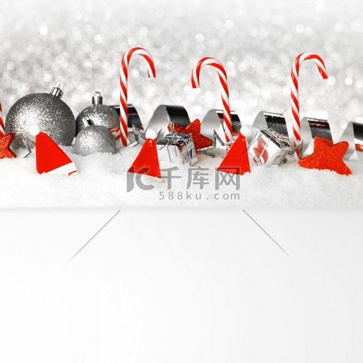 圣诞卡与装饰小玩意儿和糖果在雪