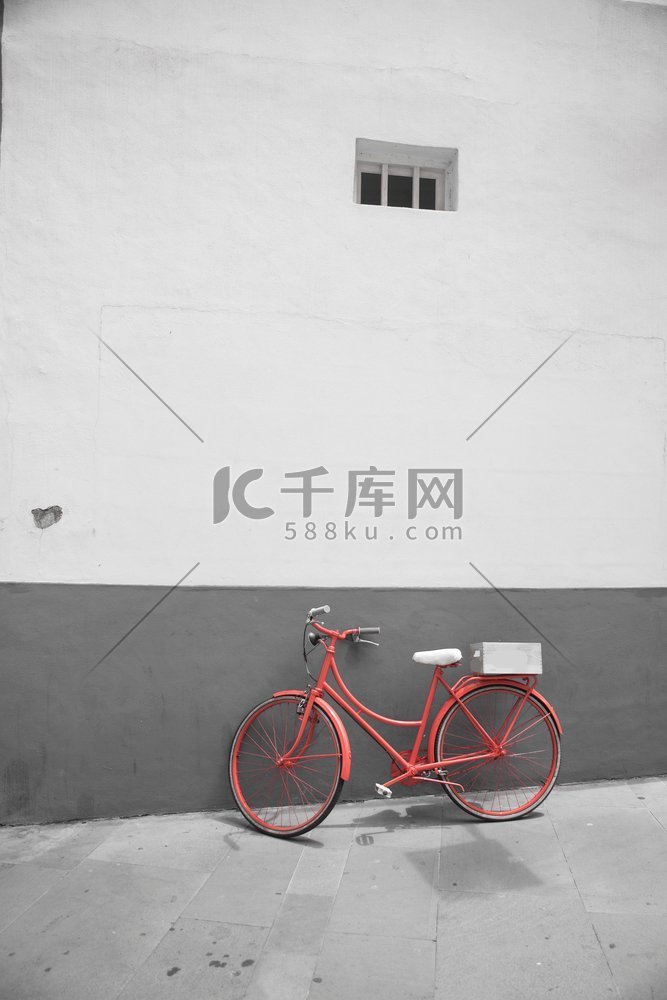 红色自行车在白色墙壁背景。黑白