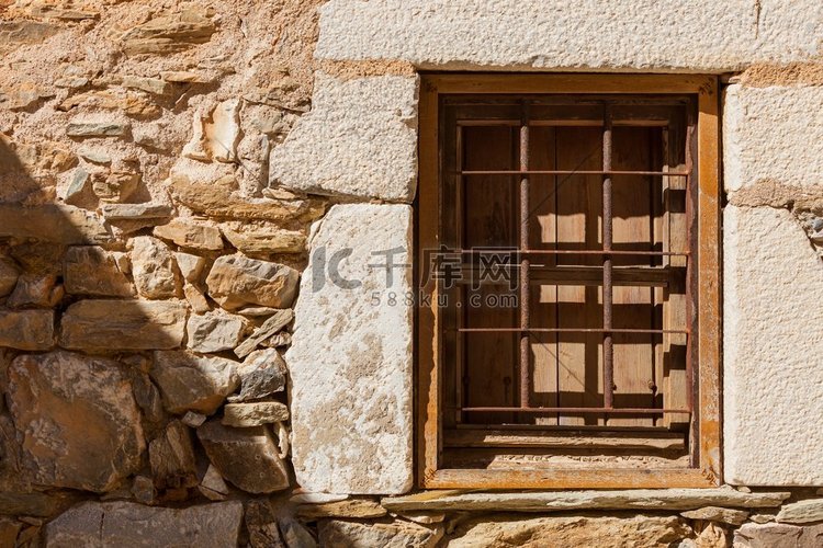 旧木窗和旧石墙上的金属格栅使建